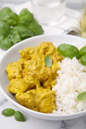 Photo of Delicious rice and chicken with curry sauce on white marble table, closeup