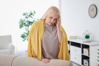 Photo of Mature woman suffering from headache at home