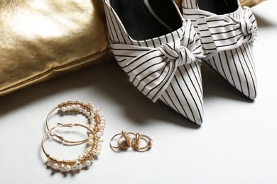 Photo of Pillow, lady's shoes and jewelry on light background, closeup