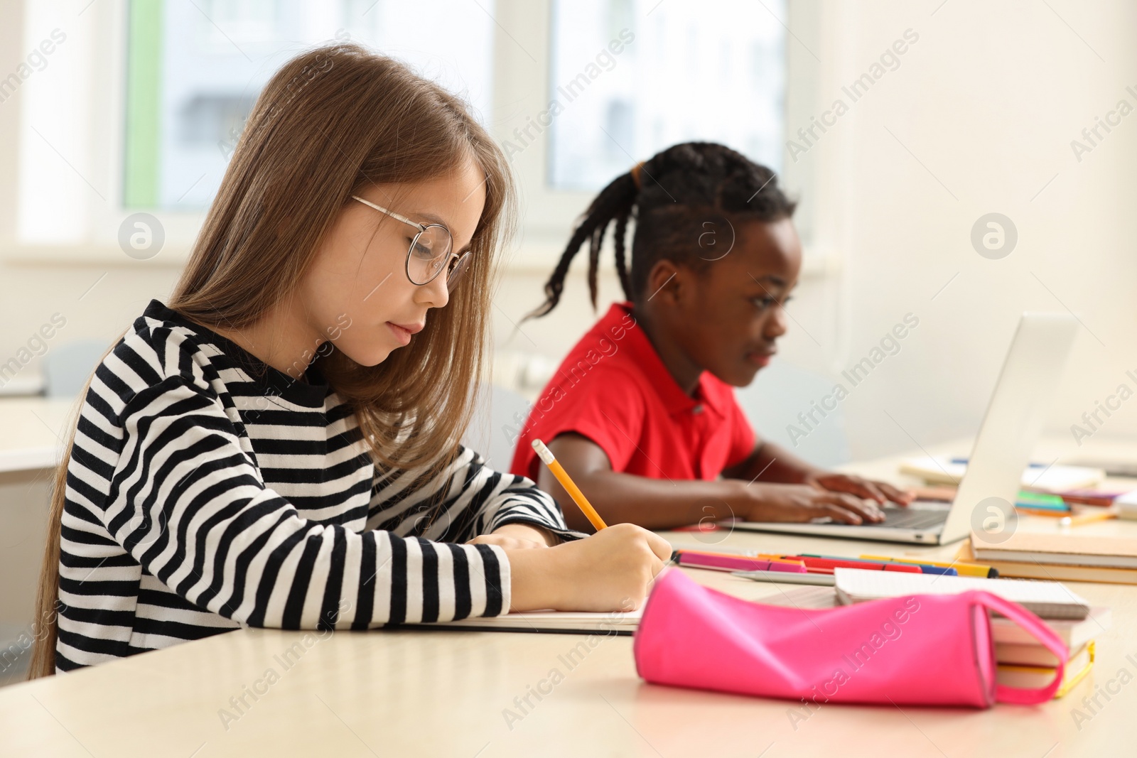 Photo of Cute children studying in classroom at school