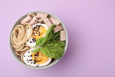 Photo of Bowl of delicious ramen with meat and egg on violet table, top view with space for text. Noodle soup