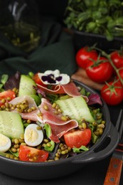 Photo of Bowl of salad with mung beans on black table, closeup
