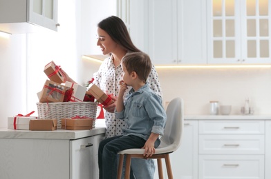 Mother and son with Christmas gifts at home. Advent calendar in basket