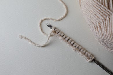 Photo of Soft yarn, knitting and metal needles on light background, top view