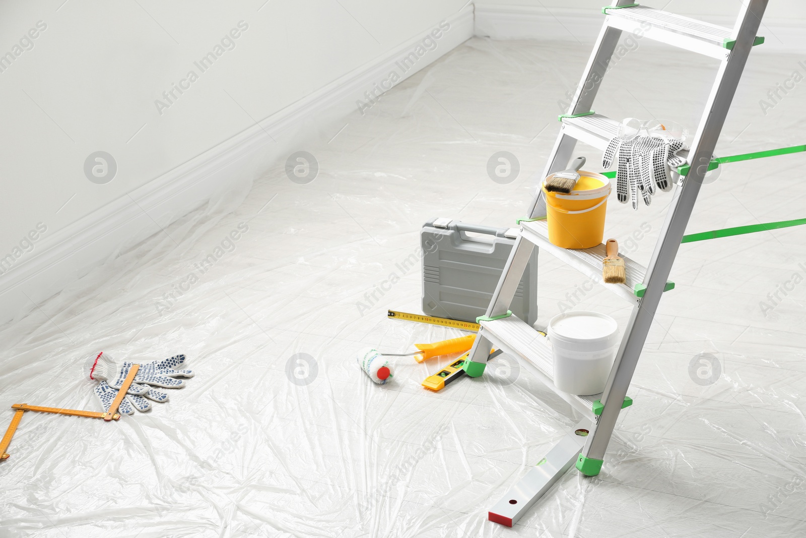 Photo of Stepladder and different tools in room. Interior renovation