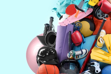 Photo of Many different sports equipment on light blue background