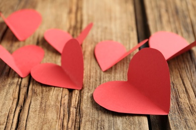 Photo of Red paper hearts on wooden table. St. Valentine's day