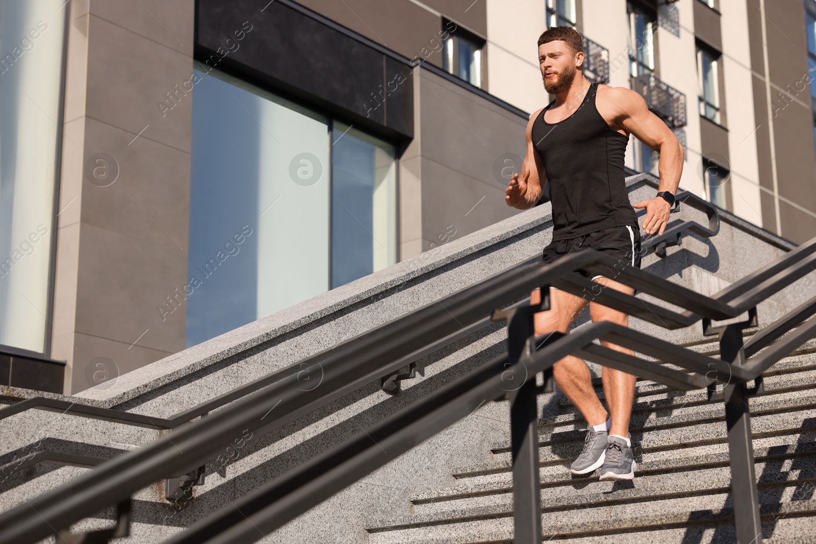 Photo of Man running down stairs outdoors on sunny day. Space for text