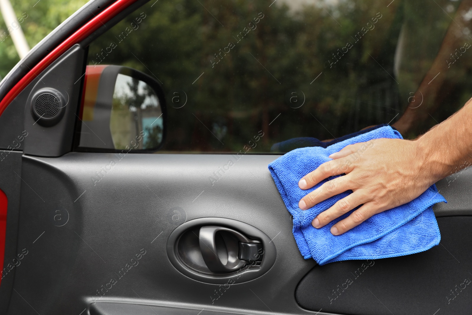 Photo of Man cleaning automobile door with duster, closeup. Car wash service