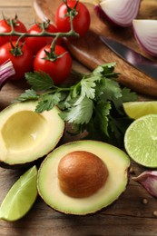 Fresh ingredients for guacamole on wooden table