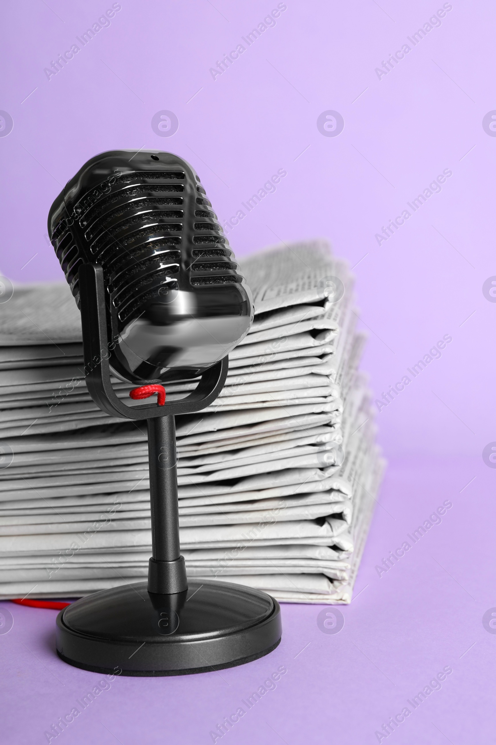 Photo of Newspapers and vintage microphone on light violet background. Journalist's work