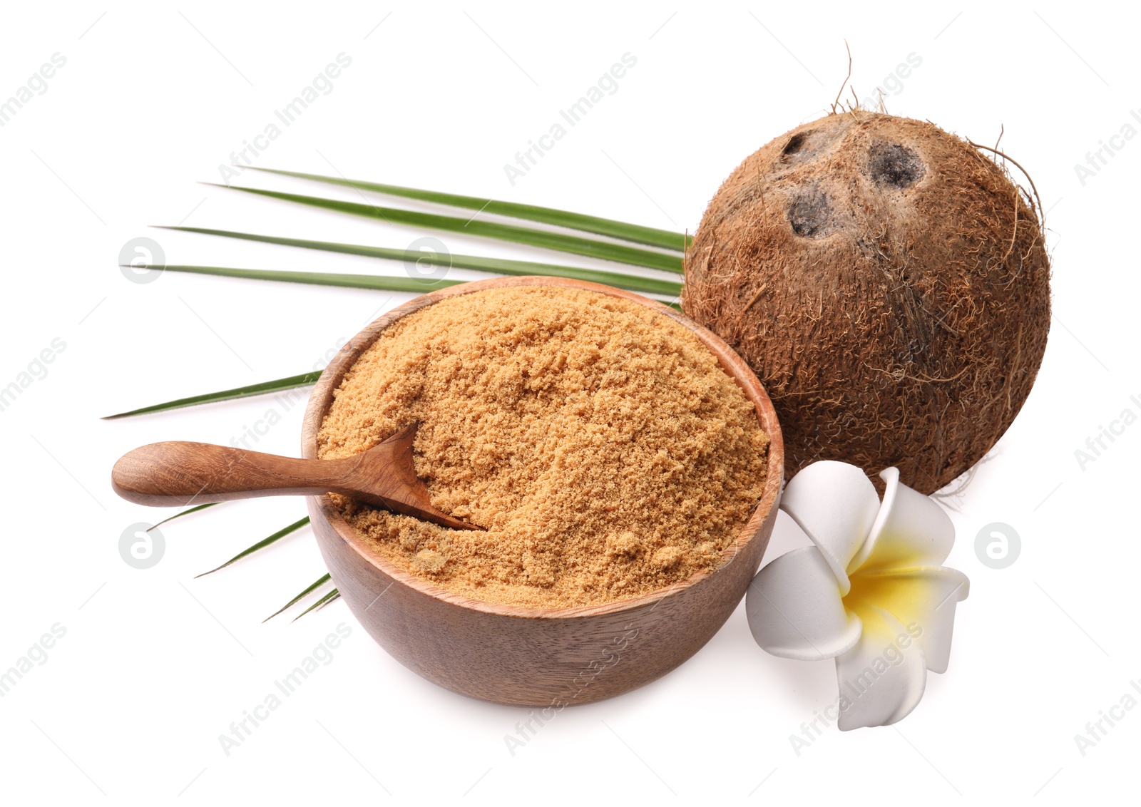 Photo of Coconut sugar in bowl, spoon, fruit and beautiful plumeria flower isolated on white