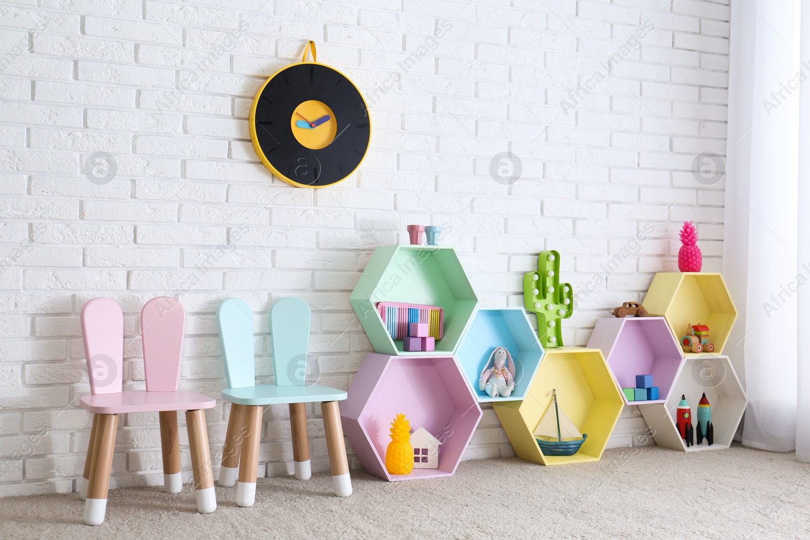 Photo of Child room interior with colorful shelves near brick wall