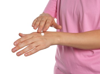 Woman applying cream on her hand against white background, closeup