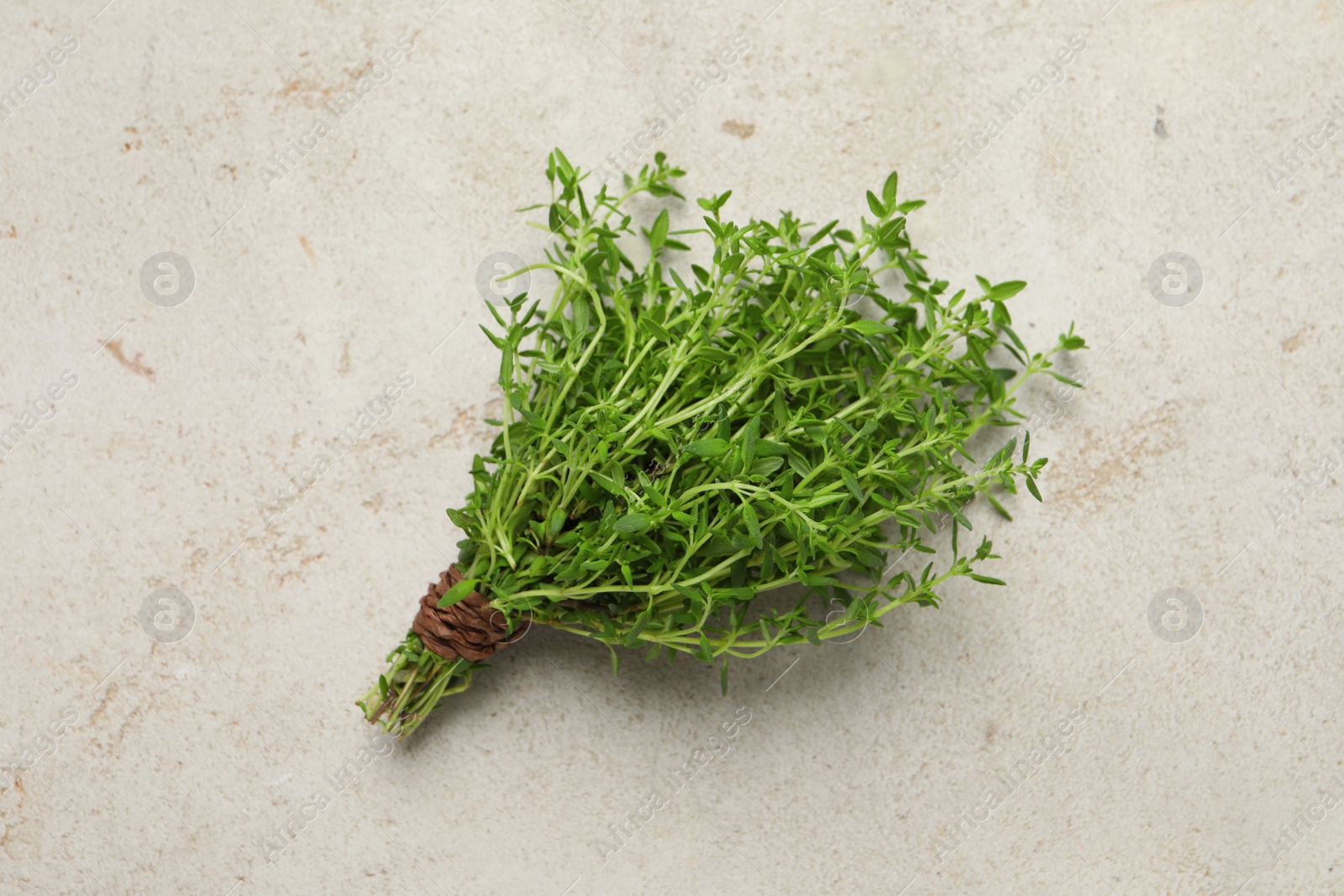 Photo of Bunch of aromatic thyme on light table, top view