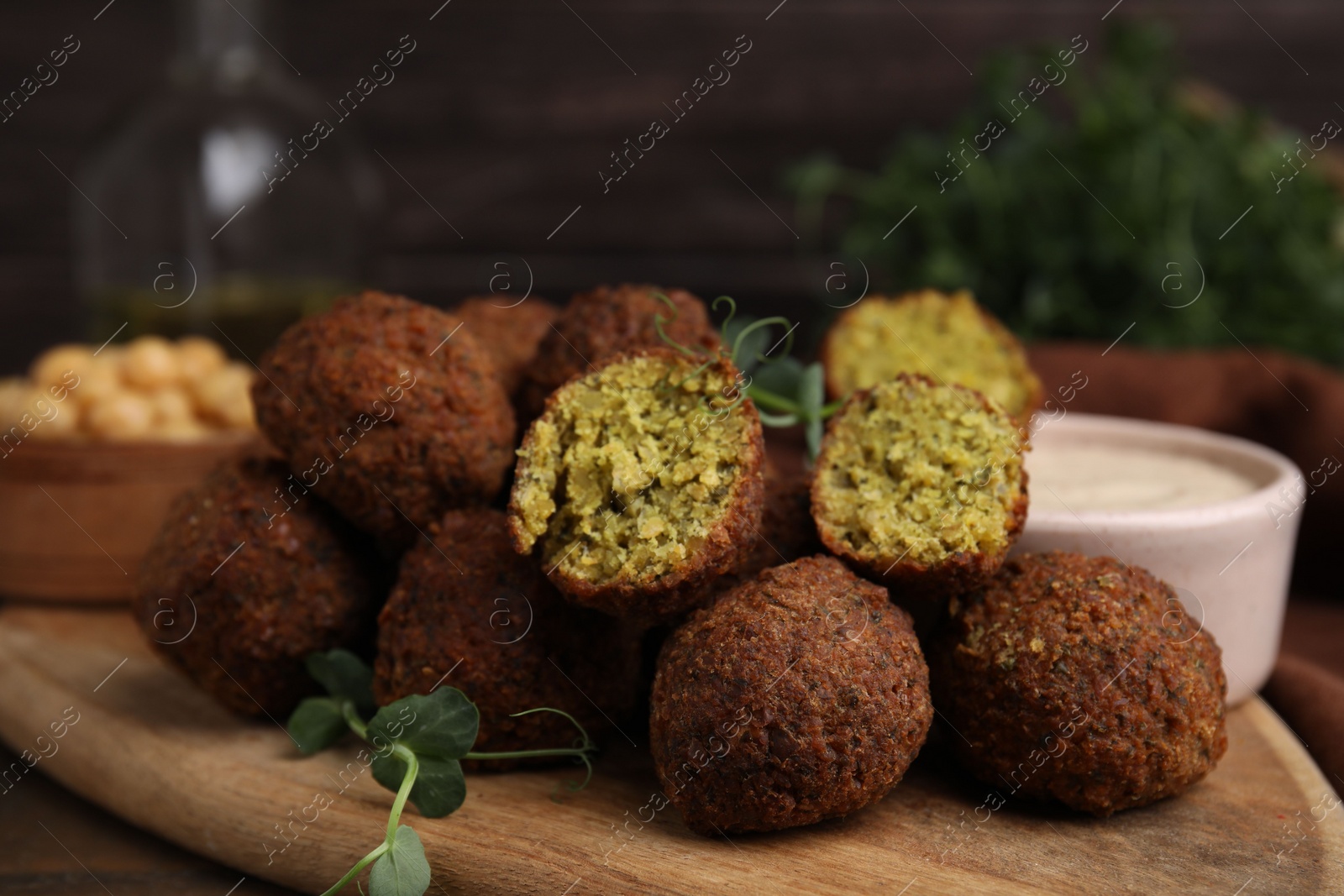 Photo of Delicious falafel balls and sauce on table, closeup