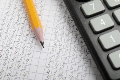 Photo of Calculator and pencil on document with data, closeup view