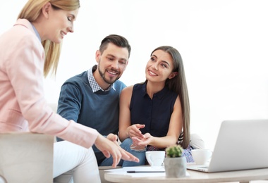 Photo of Female real estate agent working with couple in office