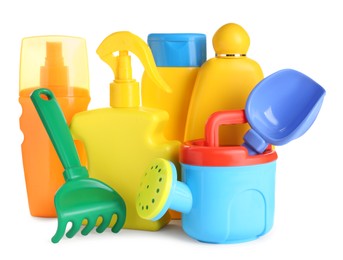 Different suntan products and plastic beach toys on white background