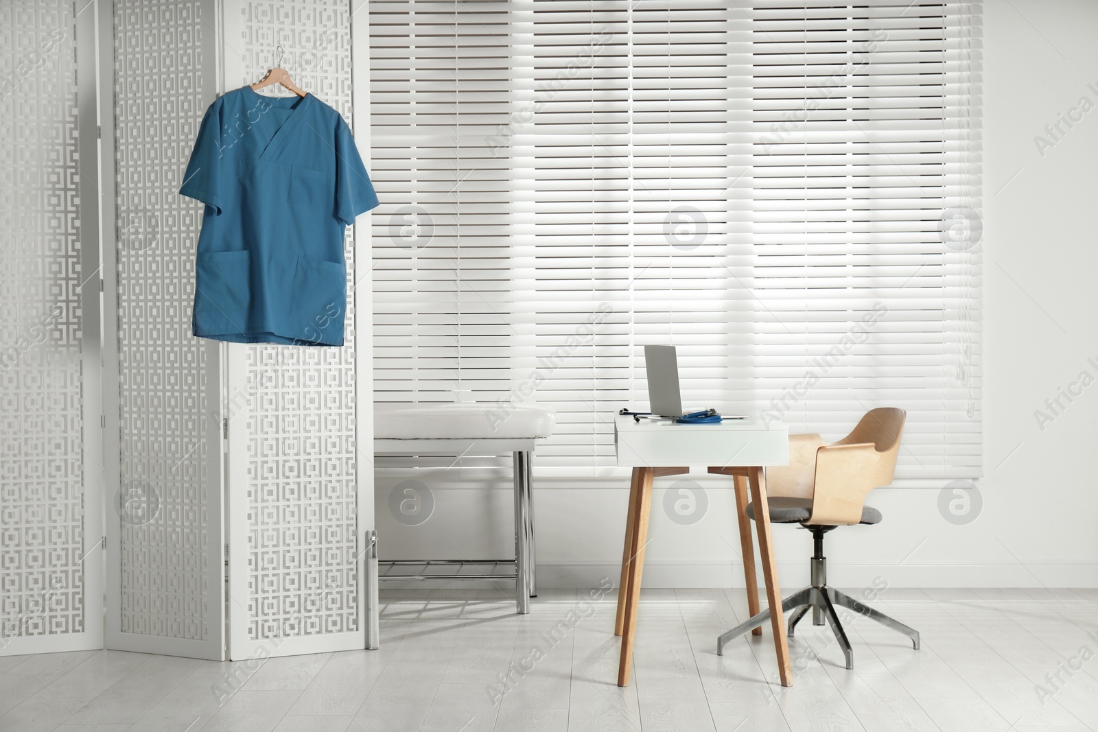 Photo of Doctor's office interior with desk and examination couch