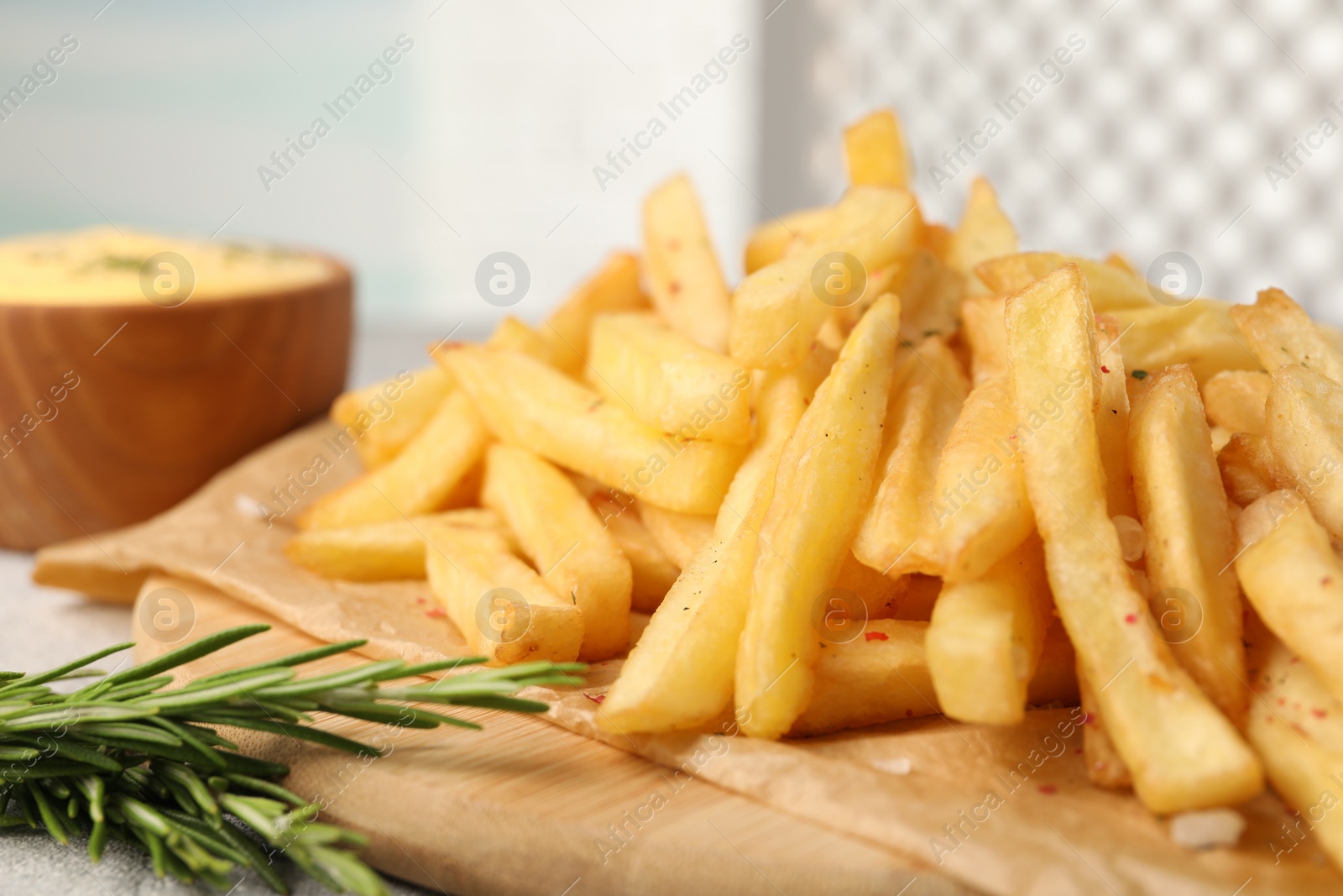 Photo of Delicious french fries with rosemary on table, closeup