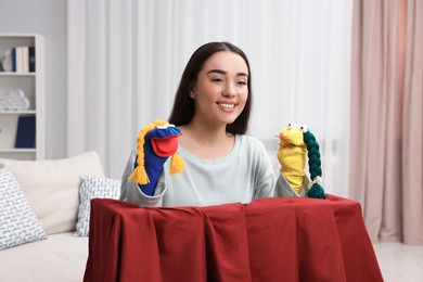 Happy woman performing puppet show at home