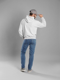 Young man in sweater on grey background. Mock up for design