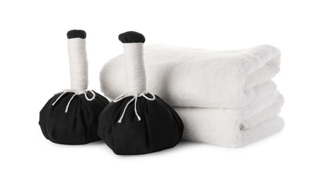 Photo of Spa composition with stacked towels and herbal massage bags on white background