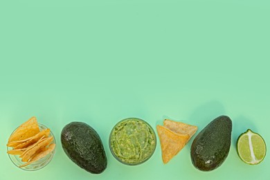 Photo of Delicious guacamole, avocados, lime and nachos on light background, flat lay. Space for text