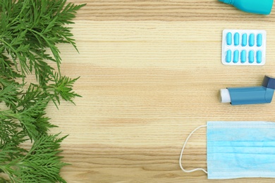 Photo of Flat lay composition with ragweed plant (Ambrosia genus) on wooden background, space for text. Seasonal allergy