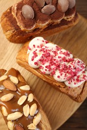 Photo of Crunchy round croissants on wooden table, top view. Tasty puff pastry