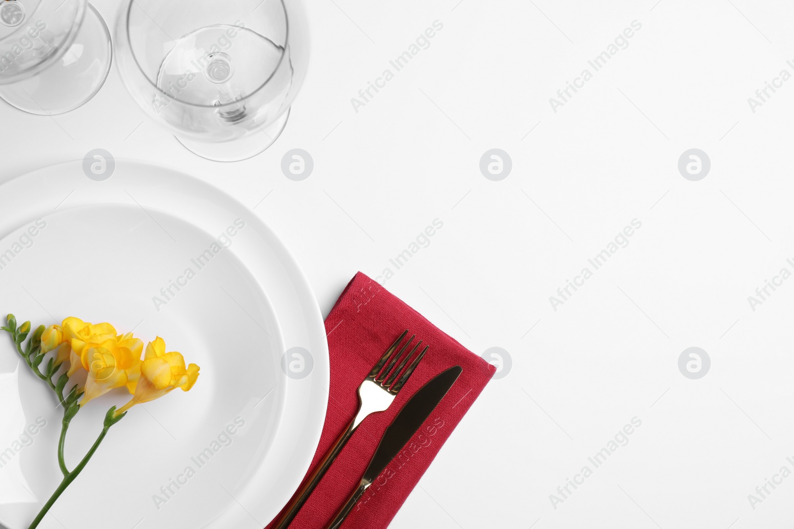 Photo of Elegant table setting with freesia on white background, top view