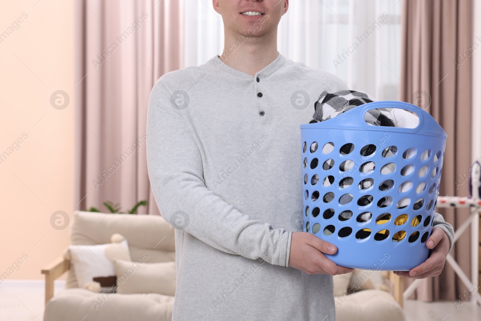 Photo of Man with basket full of laundry at home, closeup