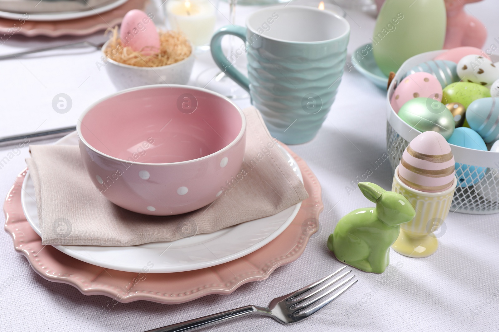 Photo of Festive table setting with painted eggs. Easter celebration