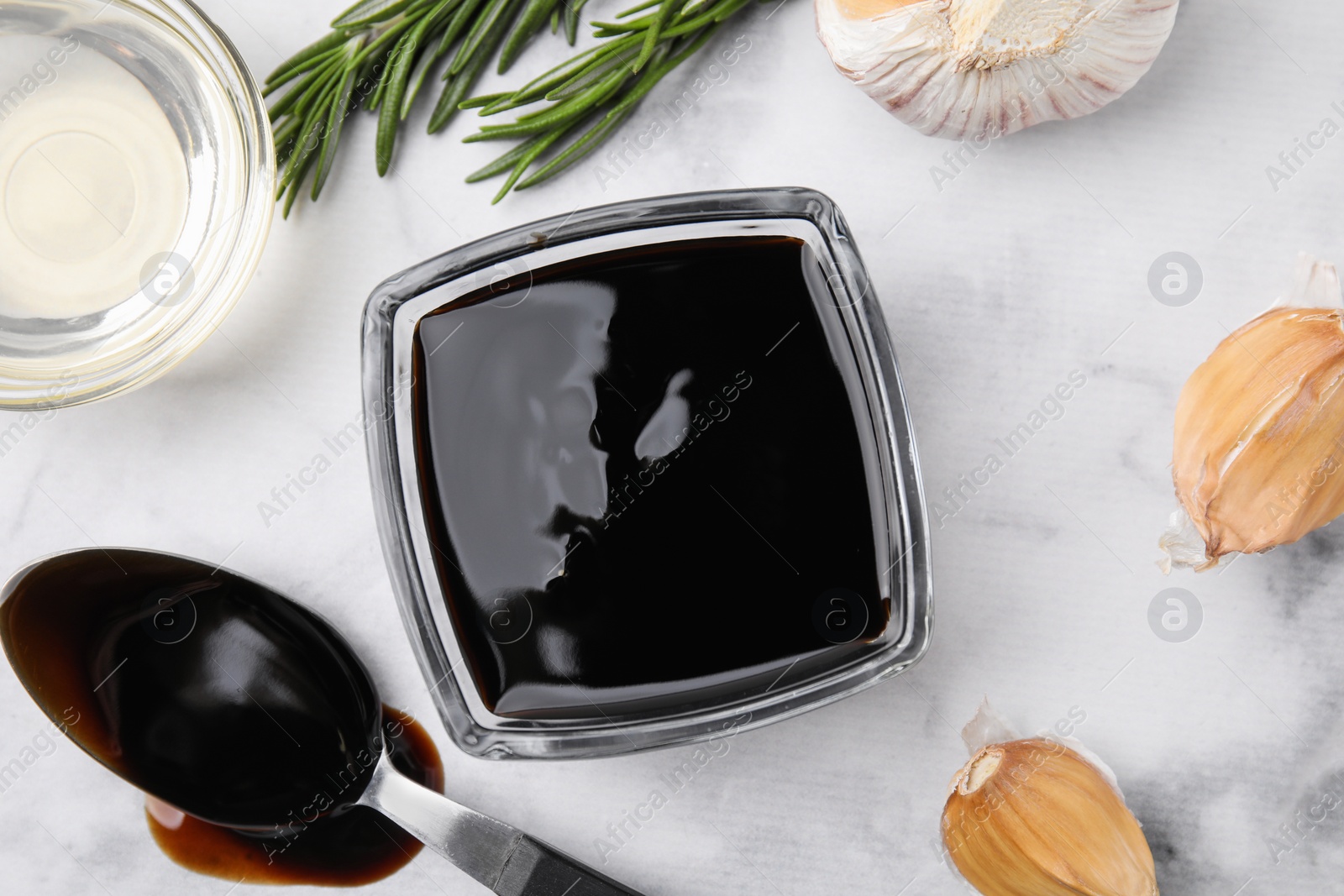 Photo of Organic balsamic vinegar and cooking ingredients on white table, flat lay