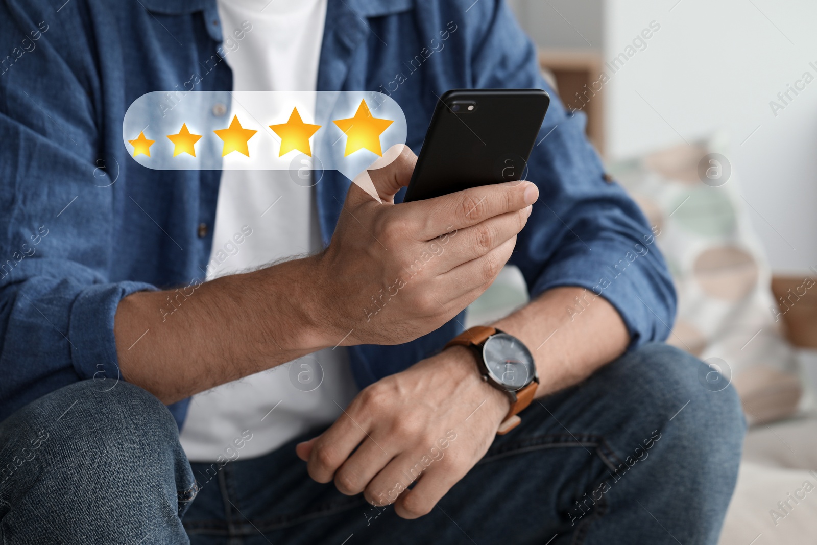 Image of Man leaving service feedback with smartphone at home, closeup. Stars over device