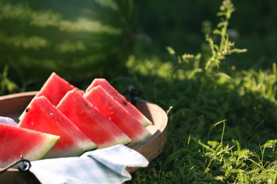 Photo of Slices of tasty ripe watermelon on green grass outdoors, closeup. Space for text