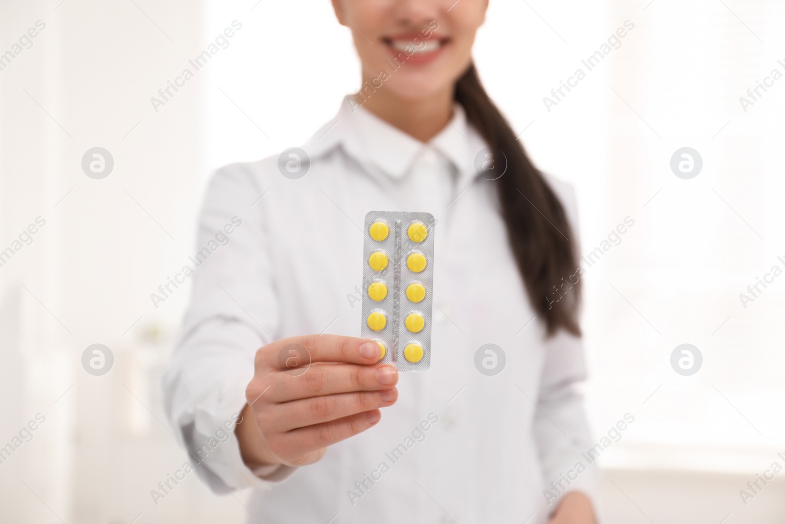 Photo of Professional pharmacist with pills in drugstore, closeup