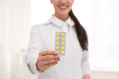 Professional pharmacist with pills in drugstore, closeup