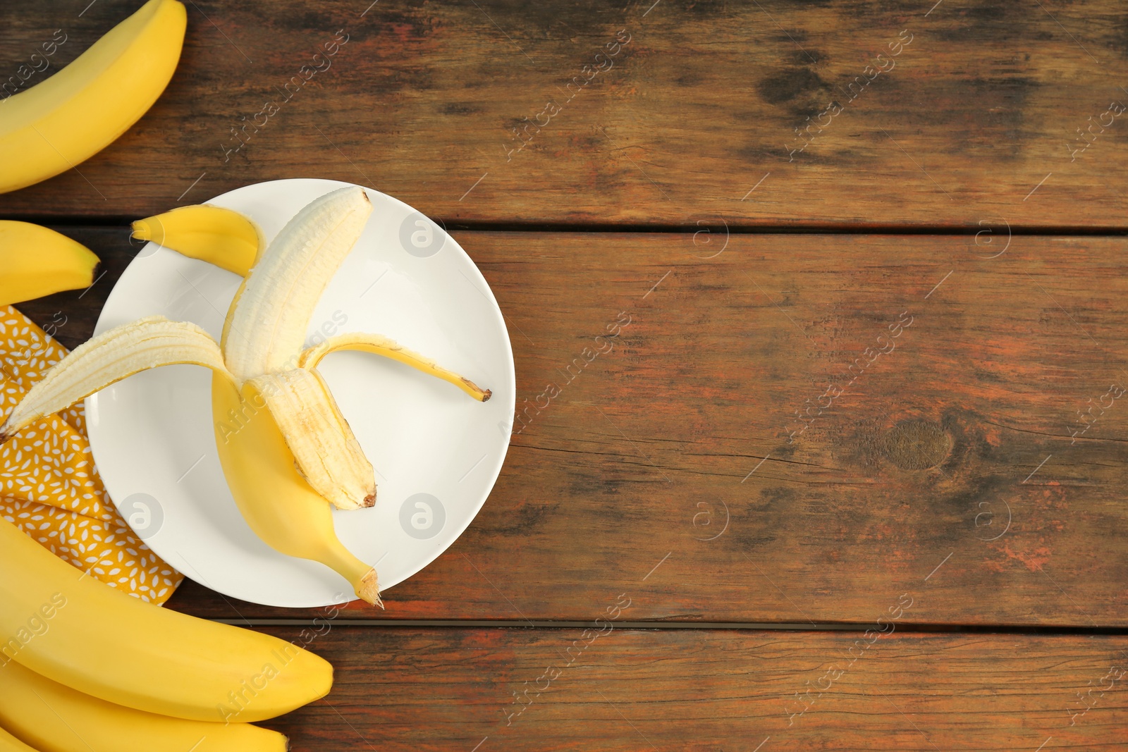 Photo of Many delicious ripe bananas on wooden table, flat lay. Space for text