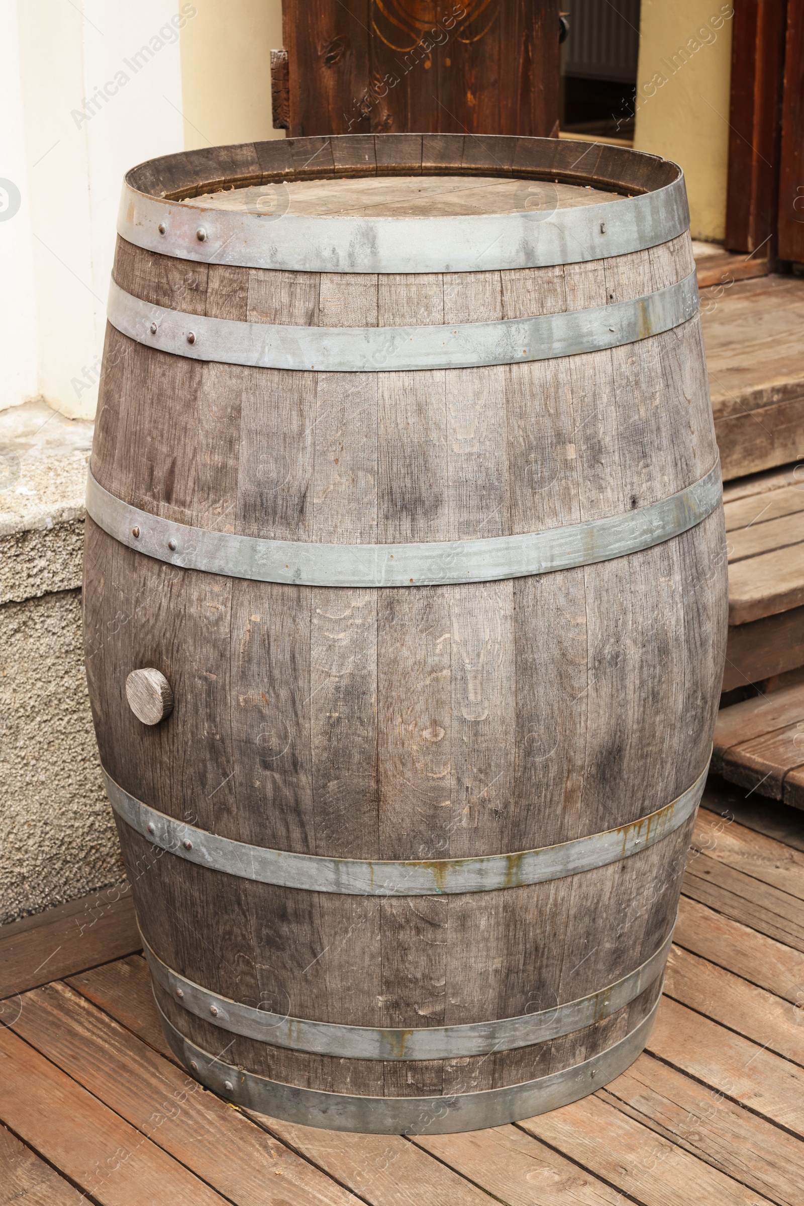 Photo of Traditional wooden barrel on street outdoors. Wine making