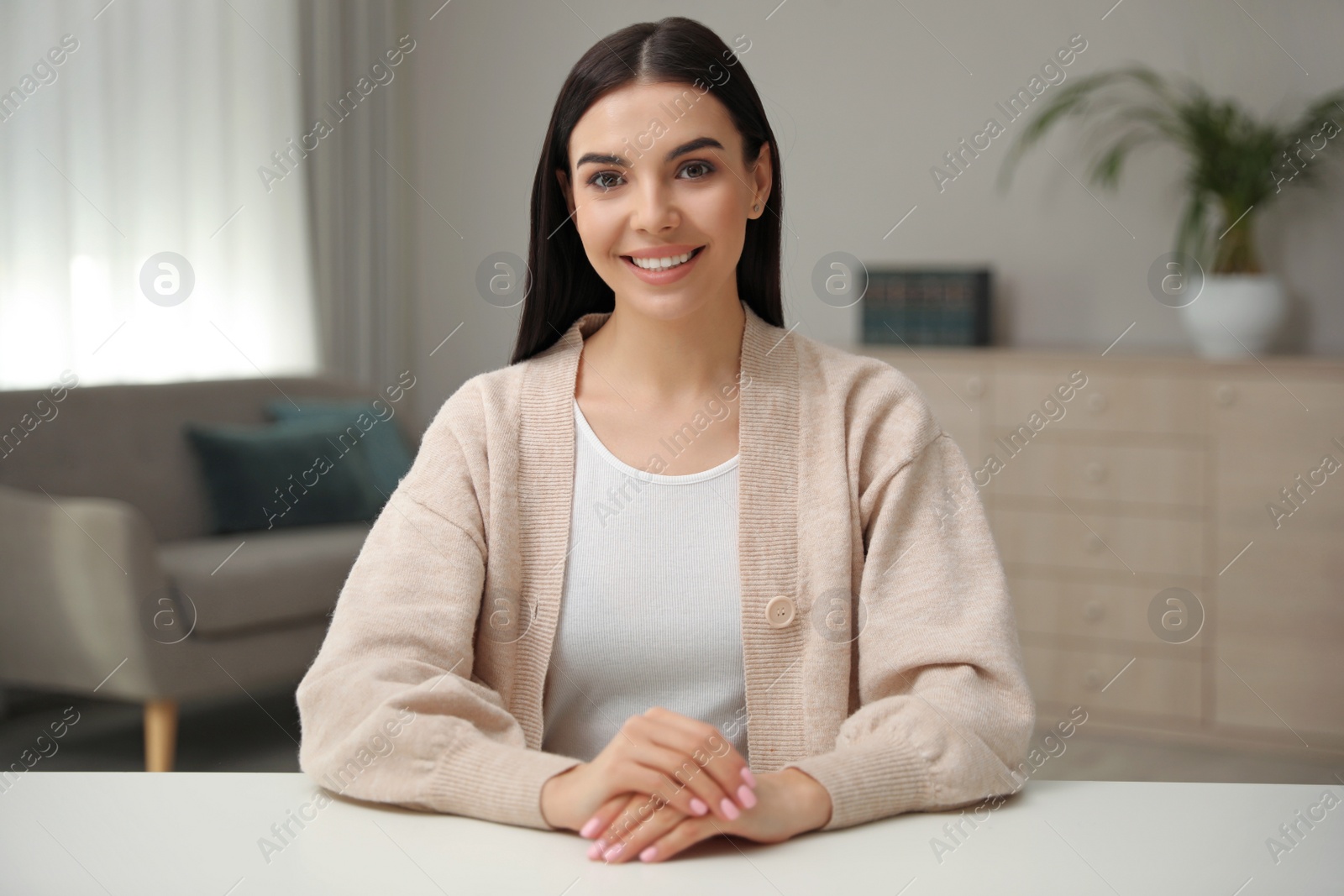 Photo of Beautiful young woman conducting webinar in room, camera view