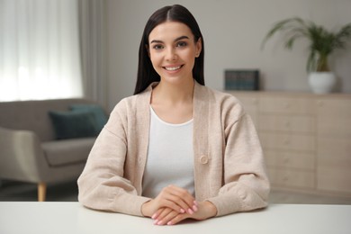 Photo of Beautiful young woman conducting webinar in room, camera view