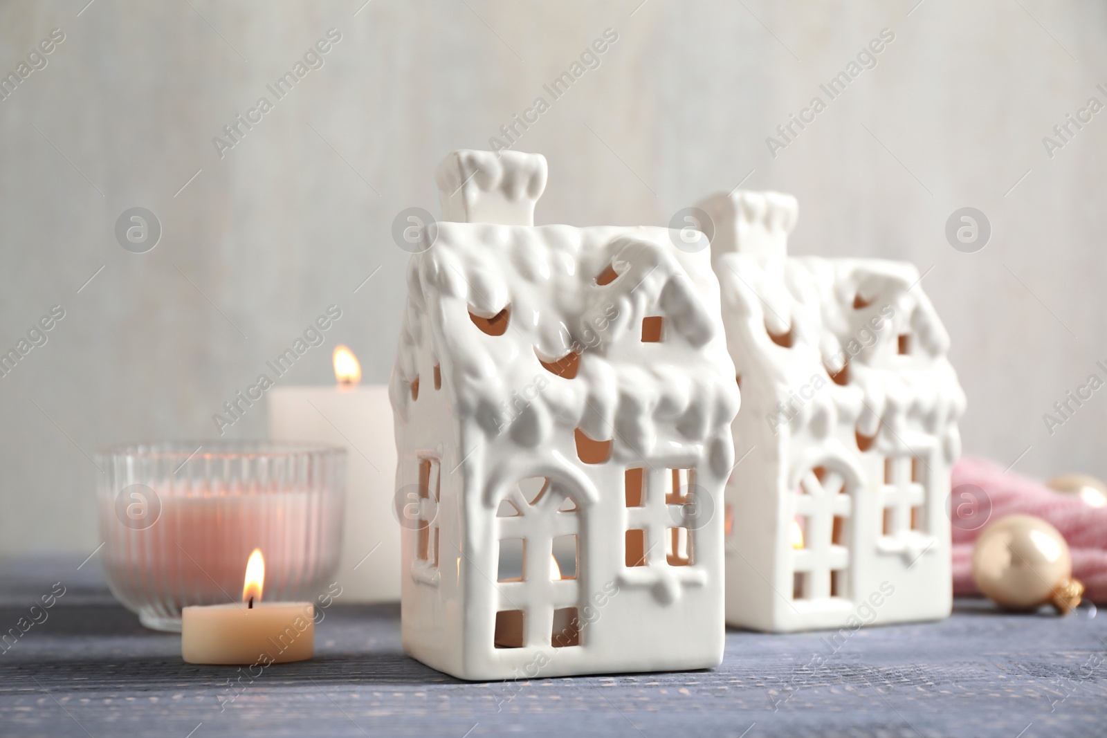 Photo of Composition with house shaped candle holders on grey wooden table. Christmas decoration