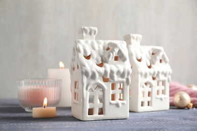 Composition with house shaped candle holders on grey wooden table. Christmas decoration