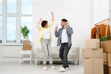 Photo of Happy couple dancing in new apartment. Moving day