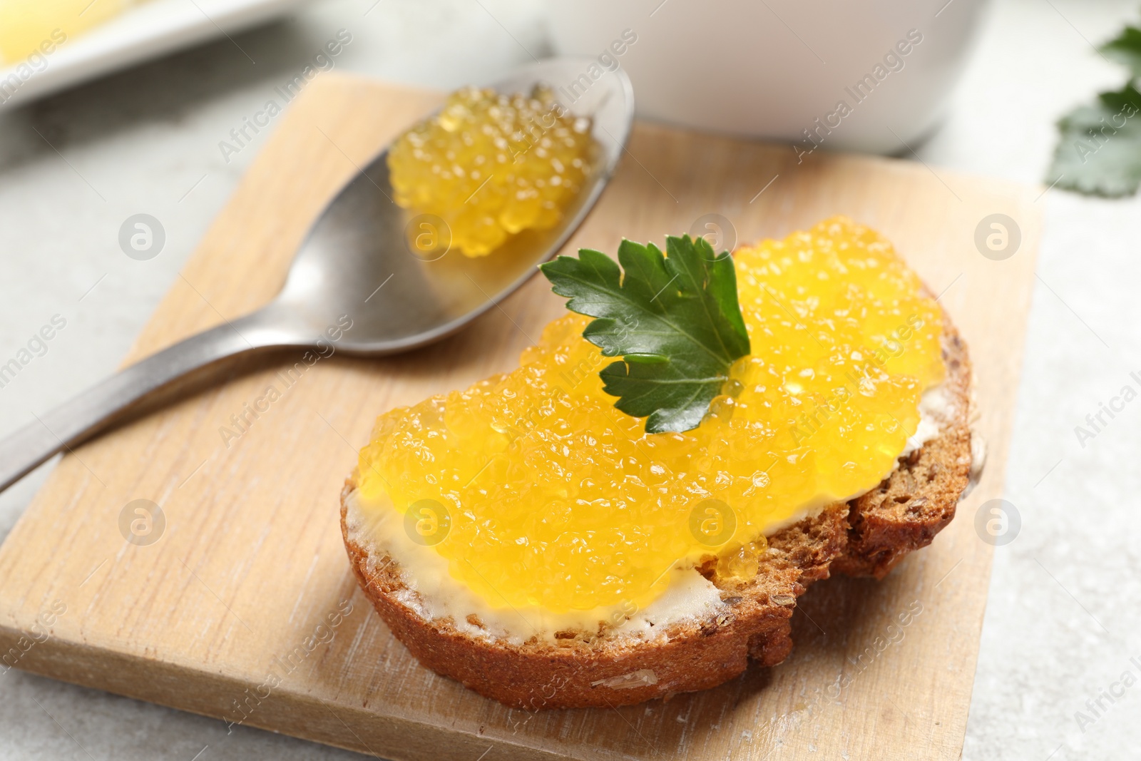 Photo of Tasty sandwich with pike caviar and parsley on table, closeup