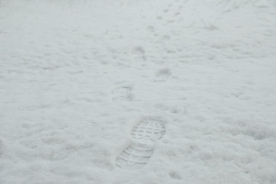 Bootprints in snow outdoors on winter day