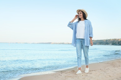 Photo of Beautiful young woman in casual outfit on beach