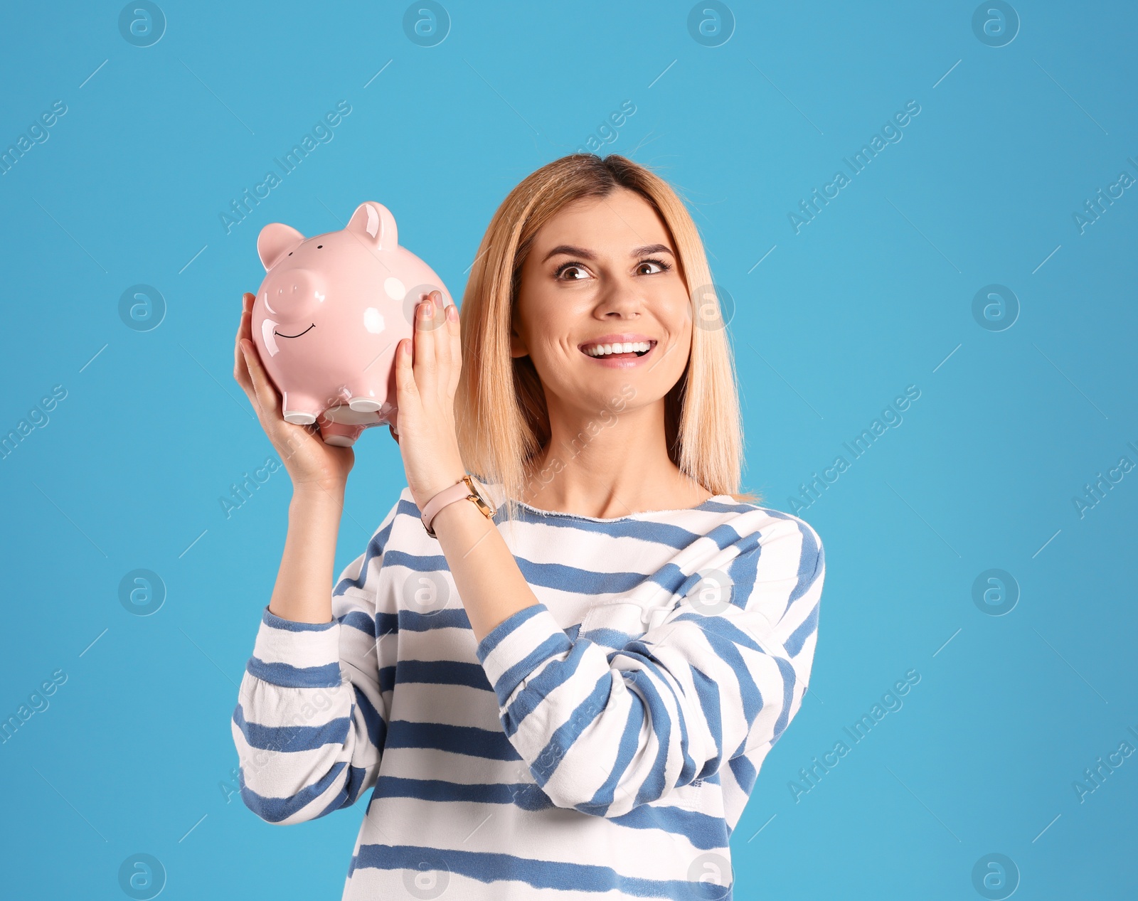 Photo of Woman with piggy bank on color background